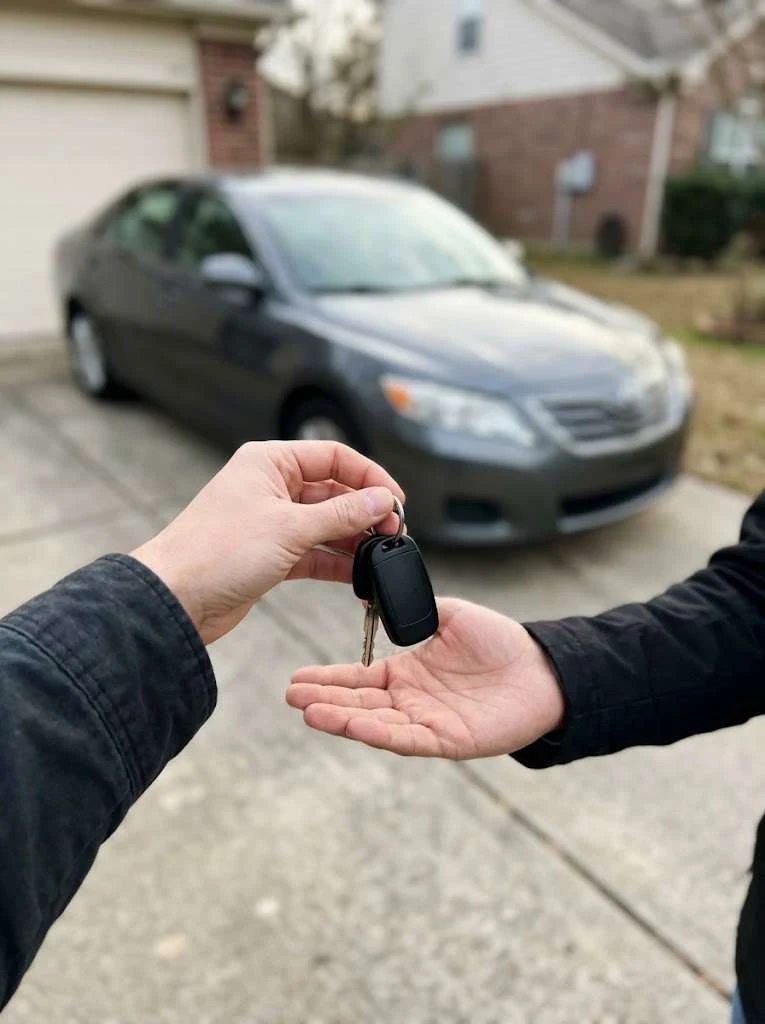 A private seller handing car keys to a dealer